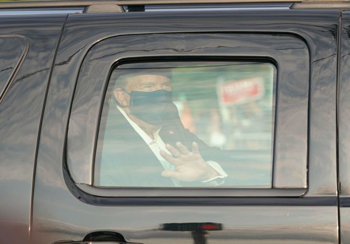 President Trump, infected with the coronavirus, waves from an SUV in a motorcade outside Walter Reed National Military Medical Center in Bethesda, Maryland on October 4, 2020. (Photo by ALEX EDELMAN/AFP via Getty Images) PHOTO CREDIT: ALEX EDELMAN/AFP