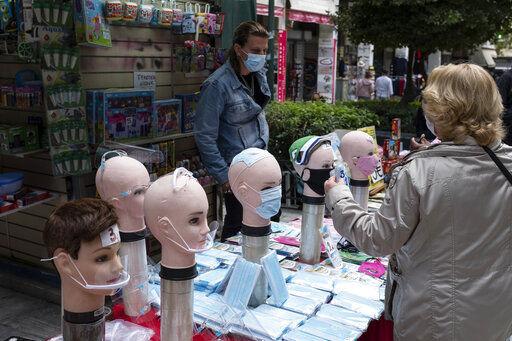 A woman buys face masks from a street vendor in Athens, Monday, Nov. 2, 2020. The government announced new lockdown measures Saturday to stem the rapid rise in new cases, among which are the closure of bars, cafes, restaurants and gyms in large swaths of the country, will take effect Tuesday through at least the end of November. (AP Photo/Yorgos Karahalis) PHOTO CREDIT: Yorgos Karahalis