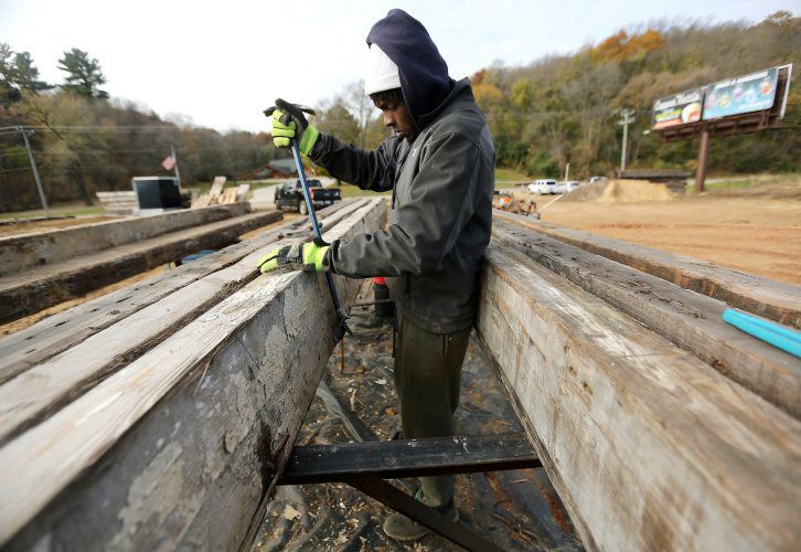 Keyshauwn Lewis works on pulling nails from lumber reused from the Flexsteel building that was deconstructed recently. PHOTO CREDIT: Dave Kettering
