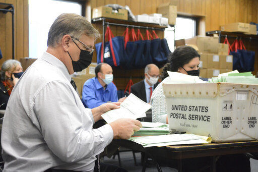 Election Bureau Director Albert L. Gricoski (left) opens provisional ballots alongside election bureau staff Christine Marmas while poll watchers observe from behind at the Schuylkill County Election Bureau in Pottsville, Pa. President Donald Trump’s campaign is withdrawing a central part of its lawsuit seeking to stop the certification of the election results in Pennsylvania. PHOTO CREDIT: Lindsey Shuey