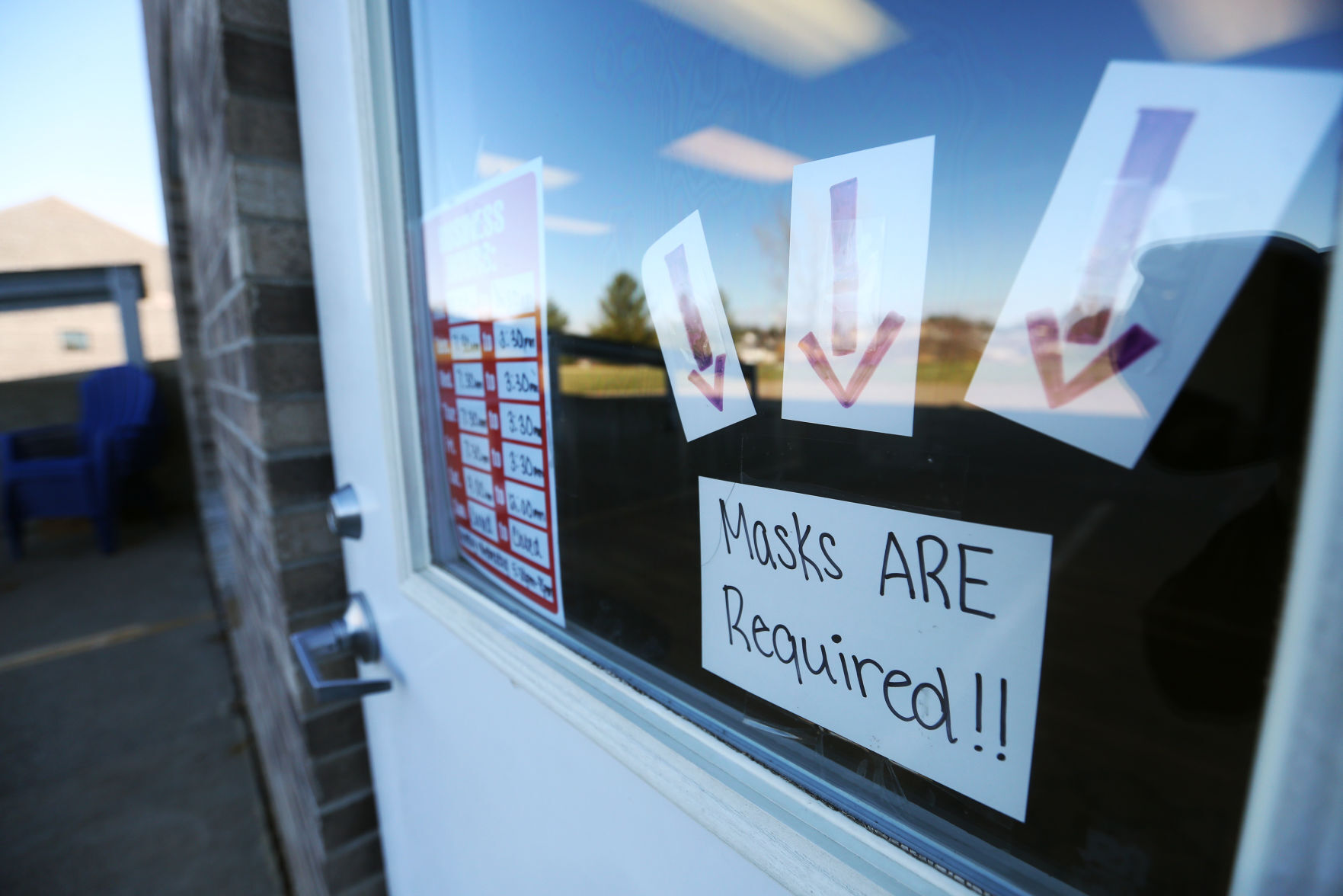 A sign regarding masks is displayed at NuFit at 5555 Saratoga Road in Asbury, Iowa, on Monday. PHOTO CREDIT: JESSICA REILLY