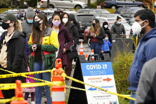 FILE - In this Nov. 18, 2020, file photo, people line up to be tested for the coronavirus at a free testing site in Seattle. With coronavirus cases surging and families hoping to gather safely for Thanksgiving, long lines to get tested have reappeared across the U.S. (AP Photo/Elaine Thompson, File) PHOTO CREDIT: Elaine Thompson