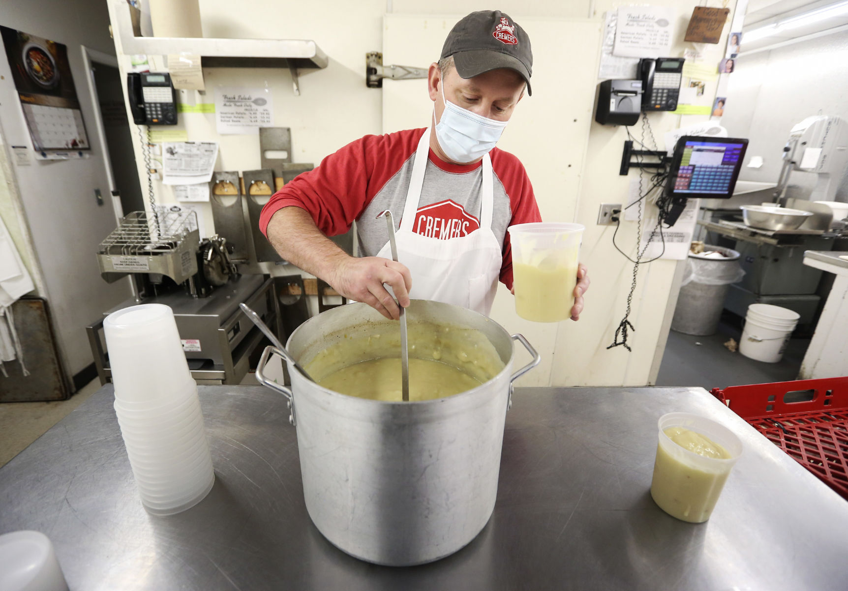 Jeff Cremer fills to-go containers of homemade turkey gravy at Cremer