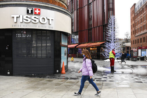 A woman wears a face mask as she walks past a closed shop, while a man cleans the pavement in Oxford Street, in London, Tuesday, Nov. 24, 2020. Haircuts, shopping trips and visits to the pub will be back on the agenda for millions of people when a four-week lockdown in England comes to an end next week, British Prime Minister Boris Johnson said Monday. (AP Photo/Alberto Pezzali) PHOTO CREDIT: Alberto Pezzali