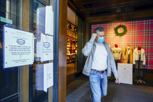 A Black Friday shopper adjusts his face mask as he leaves the Abercrombie & Fitch store along Fifth Avenue, Friday, Nov. 27, 2020, in New York. (AP Photo/Mary Altaffer) PHOTO CREDIT: Mary Altaffer