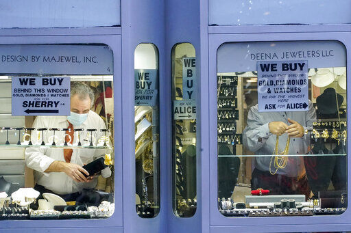 A couple of jewelers stock their windows before opening for Black Friday shoppers along Fifth Avenue, Friday, Nov. 27, 2020, in New York. (AP Photo/Mary Altaffer) PHOTO CREDIT: Mary Altaffer