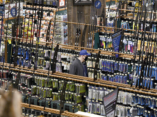 A shopper peruses an aisle of fishing rods and accessories during Black Friday at Bass Pro Shops in Foxboro, Mass. Friday, Nov. 27, 2020. The outdoor specialty store opened their doors at 5 a.m. (Mark Stockwell /The Sun Chronicle via AP) PHOTO CREDIT: Mark Stockwell / The Sun Chronicle