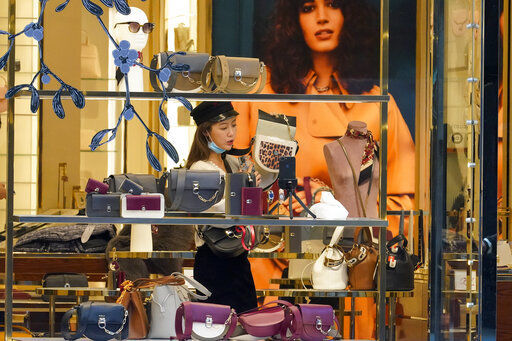 A Black Friday shopper uses her smart phone to film herself shopping for handbags at a Furla store along Fifth Avenue, Friday, Nov. 27, 2020, in New York. (AP Photo/Mary Altaffer) PHOTO CREDIT: Mary Altaffer
