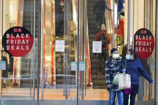 Black Friday shoppers wear face masks and gloves as the leave the Uniqlo store along Fifth Avenue, Friday, Nov. 27, 2020, in New York. (AP Photo/Mary Altaffer) PHOTO CREDIT: Mary Altaffer