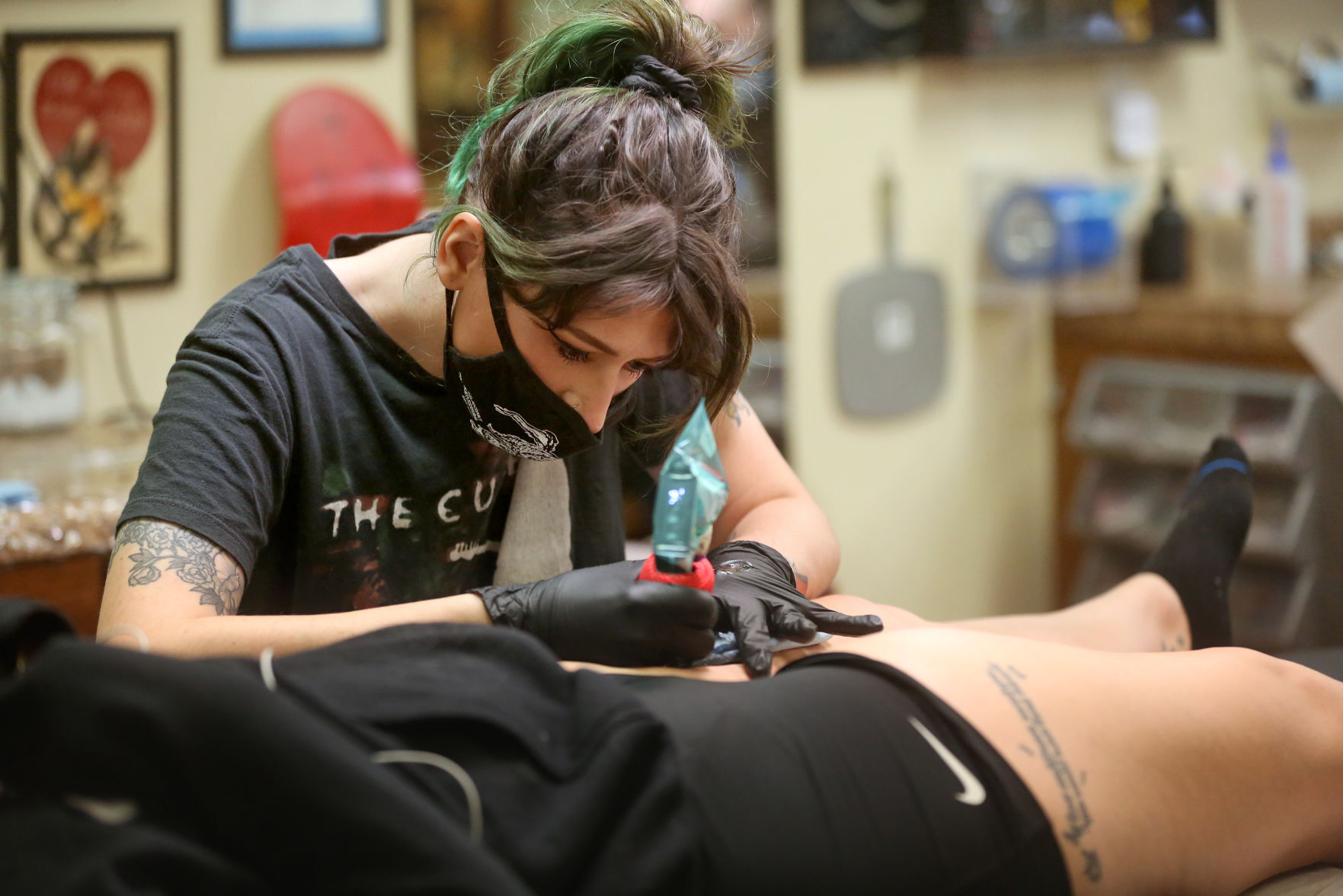 Morgan Hazer works on a tattoo for Paige Hilby, of Dubuque, at Ink Tattoo Studio in Dubuque on Saturday. PHOTO CREDIT: JESSICA REILLY