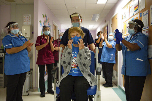 Margaret Keenan, 90, is applauded by staff as she returns to her ward after becoming the first patient in the UK to receive the Pfizer-BioNTech COVID-19 vaccine, at University Hospital, Coventry, England, Tuesday Dec. 8, 2020. The United Kingdom, one of the countries hardest hit by the coronavirus, is beginning its vaccination campaign, a key step toward eventually ending the pandemic. (Jacob King/Pool via AP) PHOTO CREDIT: Jacob King