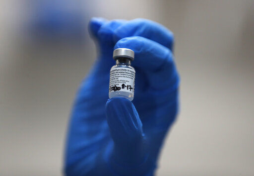 A nurse holds a phial of the Pfizer-BioNTech COVID-19 vaccine at Guy