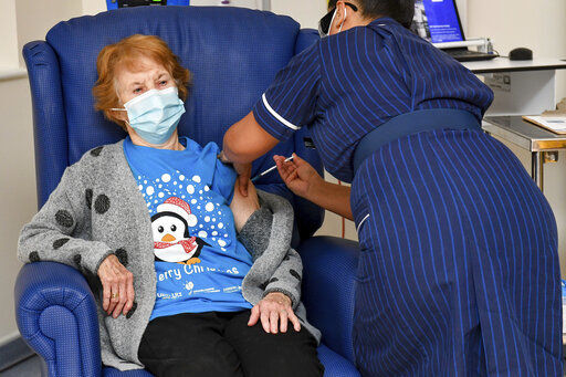 90-year-old Margaret Keenan becomes the first patient in the U.K. to receive the Pfizer-BioNTech COVID-19 vaccine, administered by nurse May Parsons at University Hospital, Coventry, England. PHOTO CREDIT: Jacob King