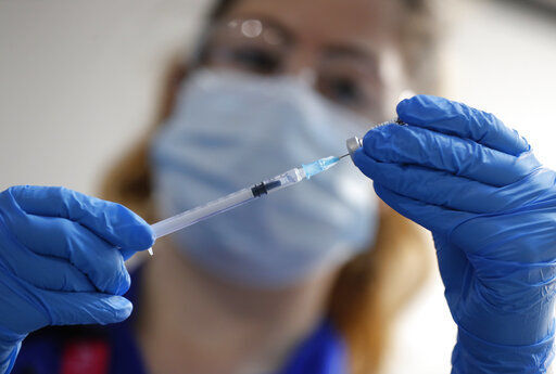 A nurse prepares a shot of the Pfizer-BioNTech COVID-19 vaccine at Guy