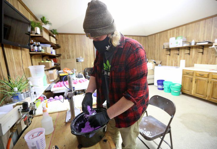 Joe Loeffelholz makes CBD bath bombs at River Bluff Collective. The business in East Dubuque, Ill., creates products based on cannabidiol, such as bath bombs and lotions. The company sells its products throughout the United States. PHOTO CREDIT: JESSICA REILLY