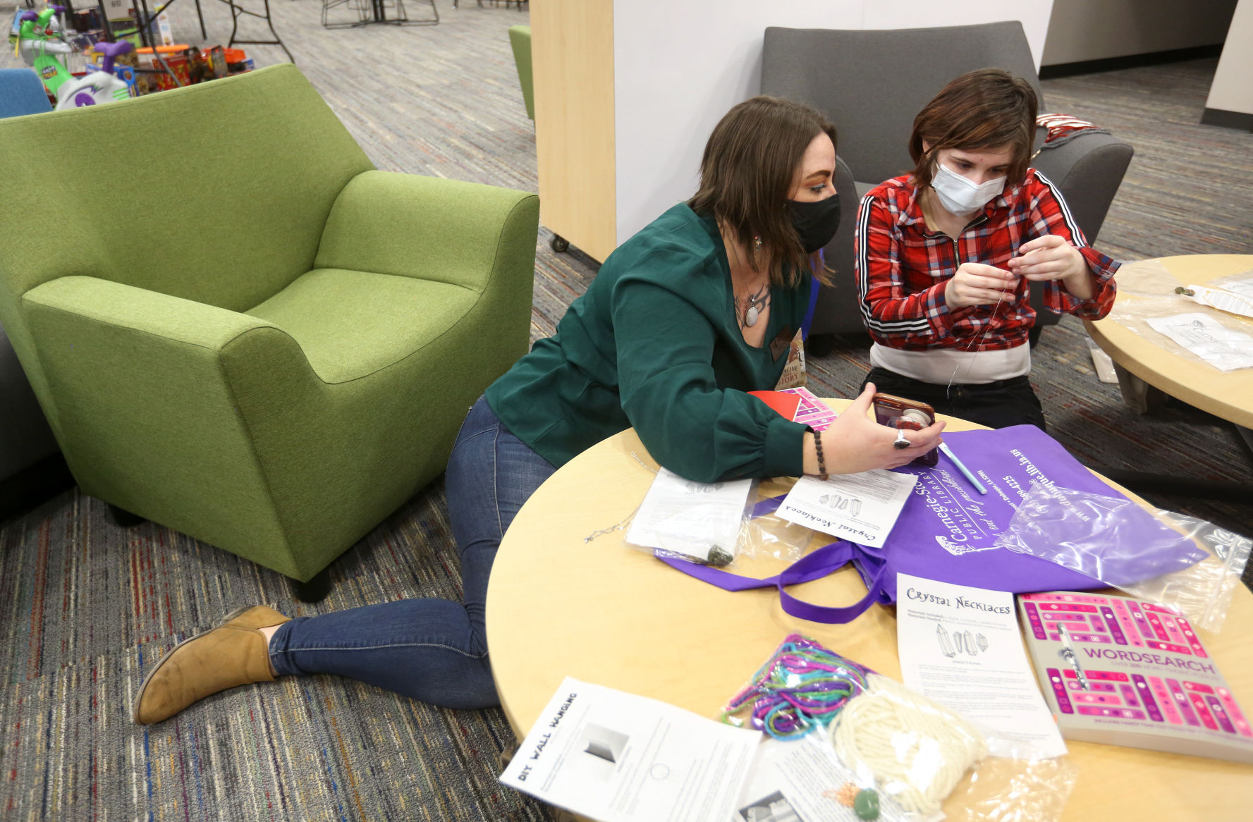Heidi Zull (left), senior site supervisor at Multicultural Family Center, and Toby Eagles, 16, of Dubuque, work on a craft during teen night at the center in Dubuque on Wednesday, Dec. 9, 2020. PHOTO CREDIT: JESSICA REILLY