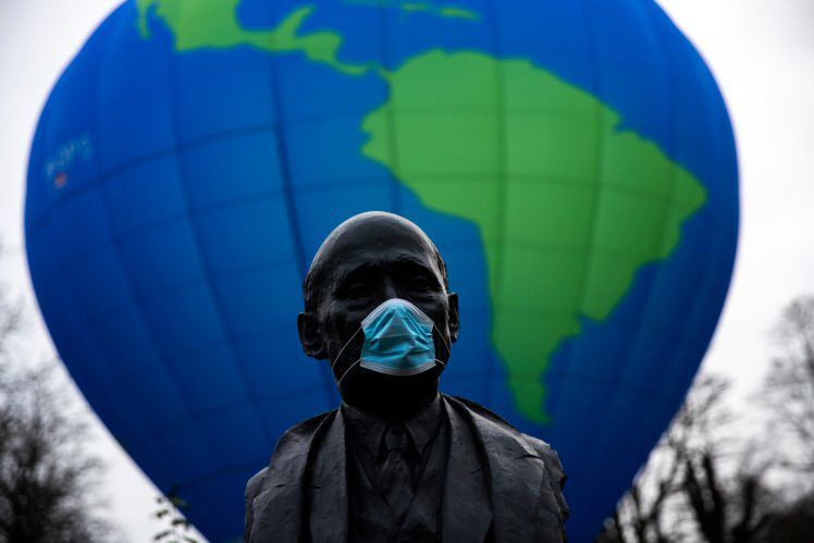 The bust of French statesman Robert Schuman, one of the founders of the European Union, is seen while environmental activists launch a hot air balloon during a demonstration outside of an EU summit in Brussels, Thursday, Dec. 10, 2020. European Union leaders meet for a year-end summit that will address anything from climate, sanctions against Turkey to budget and virus recovery plans. Brexit will be discussed on the sidelines. (AP Photo/Francisco Seco) PHOTO CREDIT: Francisco Seco