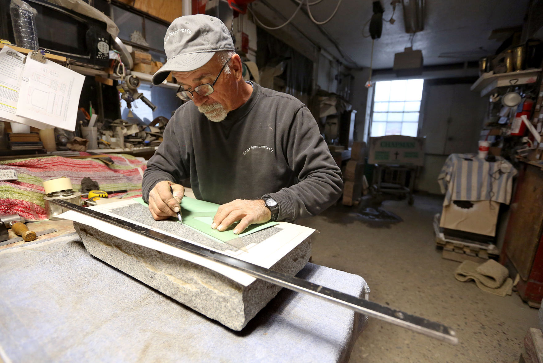 Rich Neuses works on a headstone Friday at Lenz Monument Co. in Dubuque. PHOTO CREDIT: JESSICA REILLY