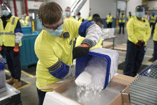 Dry ice is poured into a box containing the Pfizer-BioNTech COVID-19 vaccine as it is prepared to be shipped at the Pfizer Global Supply Kalamazoo manufacturing plant in Portage, Mich. The largest vaccination campaign in U.S. history got underway today as health workers in select hospitals rolled up their sleeves for shots to protect them from COVID-19 and start beating back the pandemic. PHOTO CREDIT: Morry Gash