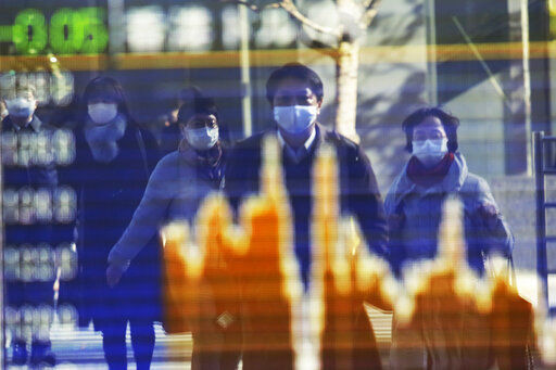 People wearing face masks to protect against the spread of the coronavirus reflected on the electronic board of a securities firm in Tokyo. American stocks rose in morning trading as investors remain optimistic that Washington will deliver another round of financial support for the economy as vaccines begin slowly rolling out to the public. PHOTO CREDIT: Koji Sasahara
