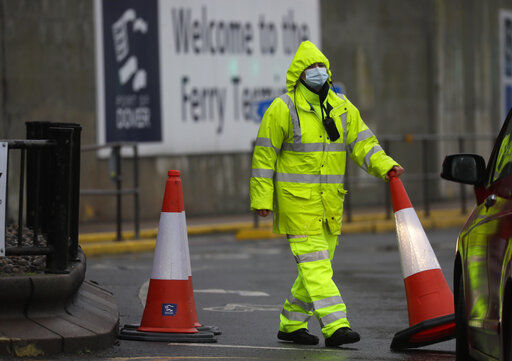 Security guard the entrance to the ferry terminal in Dover, England, Monday, Dec. 21, 2020, after the Port of Dover was closed and access to the Eurotunnel terminal suspended following the French government