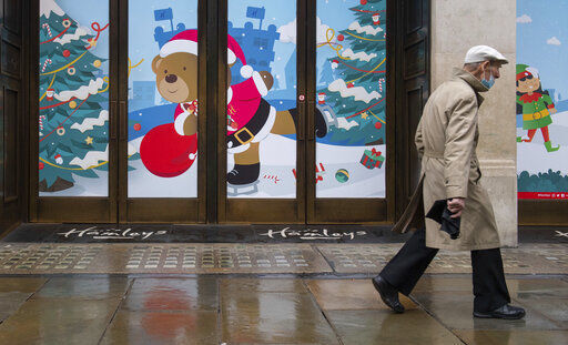 A man walks past closed shops on Regent Street, in London on Monday Dec. 21, 2020. Millions of people in England have learned they must cancel their Christmas get-togethers and holiday shopping trips. British Prime Minister Boris Johnson said Saturday that holiday gatherings can’t go ahead and non-essential shops must close in London and much of southern England. (Dominic Lipinski/PA via AP) PHOTO CREDIT: Dominic Lipinski