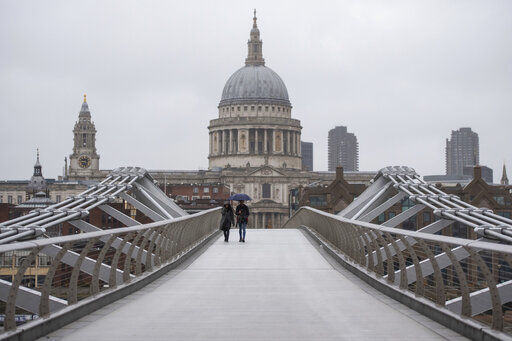 People walk across the Millennium Bridge in London, Monday Dec. 21, 2020. Millions of people in England have learned they must cancel their Christmas get-togethers and holiday shopping trips. British Prime Minister Boris Johnson said Saturday that holiday gatherings can’t go ahead and non-essential shops must close in London and much of southern England. (Dominic Lipinski/PA via AP) PHOTO CREDIT: Dominic Lipinski
