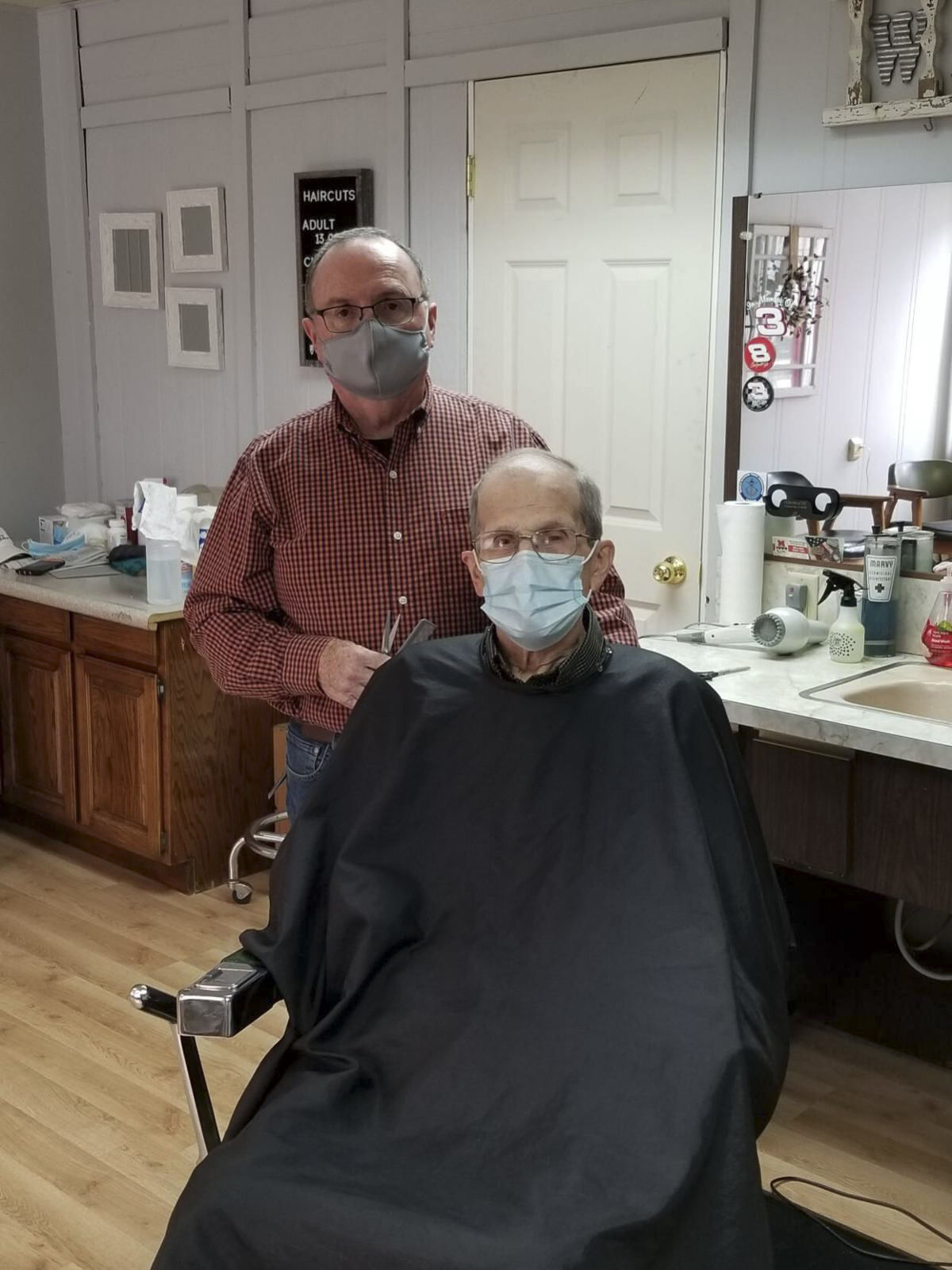 Terry Frasher cuts the hair of Ed Kleitsch, his longest constant customer. PHOTO CREDIT: Contributed