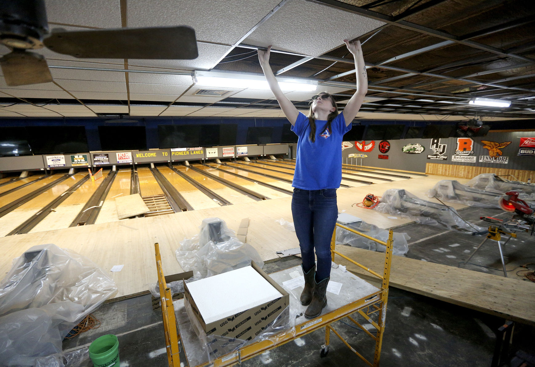 Maddy Haack installs a drop ceiling at Pioneer Lanes in Platteville, Wis., on Tuesday. Repair and renovation work at the facility continues after a fire caused major damage last month. PHOTO CREDIT: Dave Kettering