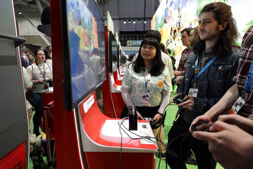 Visitors to the Pax East conference play the new Nintendo Switch video game Animal Crossing in February.  Launched in 2017, the Switch became a fast seller. That was helped by the launch of the handled Switch Lite in September 2019. In March, it became hard to find a Switch as people searched for ways to be entertained inside their homes. PHOTO CREDIT: Steven Senne