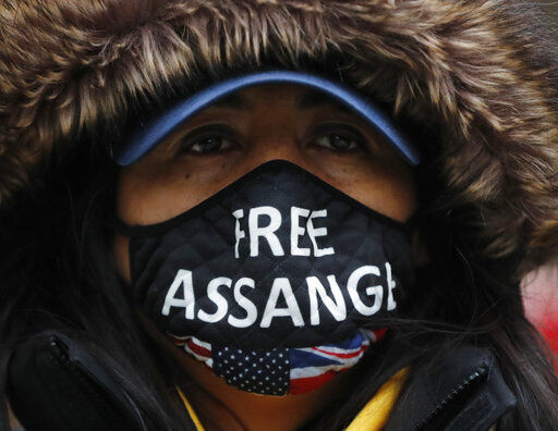 A Julian Assange supporter wears a face mask bearing his name outside the Old Bailey in London, Monday, Jan. 4, 2021. Judgement is to be made by Judge Vanessa Baraitser on Julian Assange