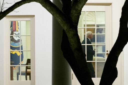 Vice President Mike Pence walks through the Oval Office before President Donald Trump departs the White House in Washington. Pence finds himself in the most precarious position of his tenure as he prepares to preside over Wednesday