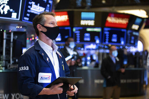 In this photo provided by the New York Stock Exchange, trader Robert Charmak works on the floor, Tuesday, Jan. 5, 2021. U.S. stocks are wobbling between small gains and losses on Tuesday, a day after dropping to their worst loss in months amid the worsening pandemic and potentially market-moving Senate elections. (Colin Ziemer/New York Stock Exchange via AP) PHOTO CREDIT: Colin Ziemer