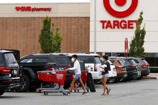 FILE - In this Aug. 4, 2020 file photo, shoppers take purchases to their vehicle in the parking lot of a Target store in Marlborough, Mass. Target’s strong sales streak extended through the holiday season, as shoppers snapped up everything from clothing to home goods during the pandemic. The Minneapolis company reported Wednesday, Jan. 13, 2021, that its online sales surged 102% for the November and December period. (AP Photo/Bill Sikes) PHOTO CREDIT: Bill Sikes