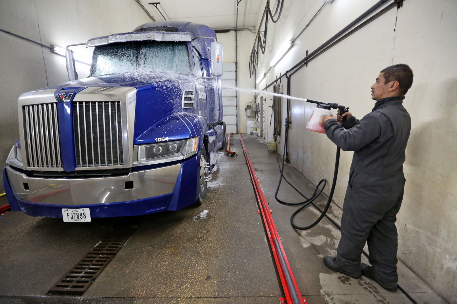 Tommy Brokus washes a semi-truck at Tucker Freight Lines in Dubuque on Tuesday, Jan. 12, 2021. PHOTO CREDIT: JESSICA REILLY