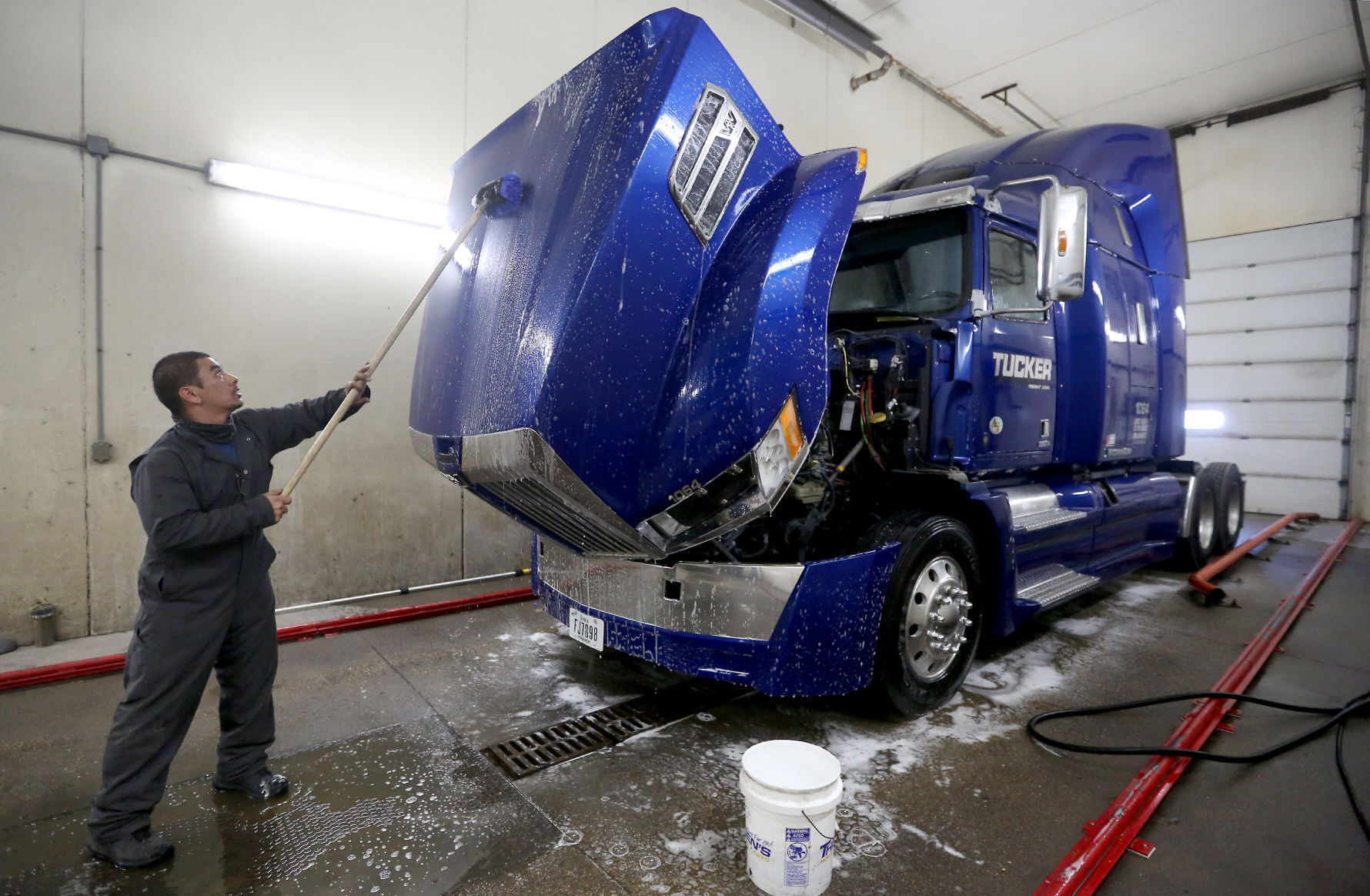Tommy Brokus washes a semi-truck at Tucker Freight Lines in Dubuque on Tuesday. PHOTO CREDIT: JESSICA REILLY