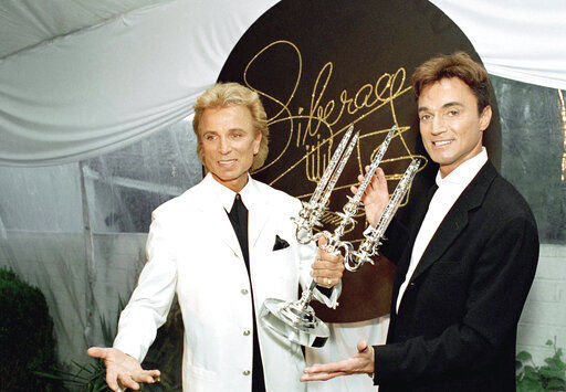FILE - Illusionists Siegfried Fischbacher, left, and Roy Horn pose after receiving the second annual Liberace Legend Award at a gala benefit in Las Vegas on May 17, 1995. German news agency dpa is reporting that Fischbacher, the surviving member of duo Siegfried & Roy has died in Las Vegas at age 81. The news agency said Thursday that Fischbacher’s sister, a nun who lives in Munich, confirmed his death of cancer. Fischbacher’s long-time show business partner, Roy Horn, died in May of complications from COVID-19 at a Las Vegas hospital. (AP Photo/Lennox McLendon, File) PHOTO CREDIT: Lennox McLendon
