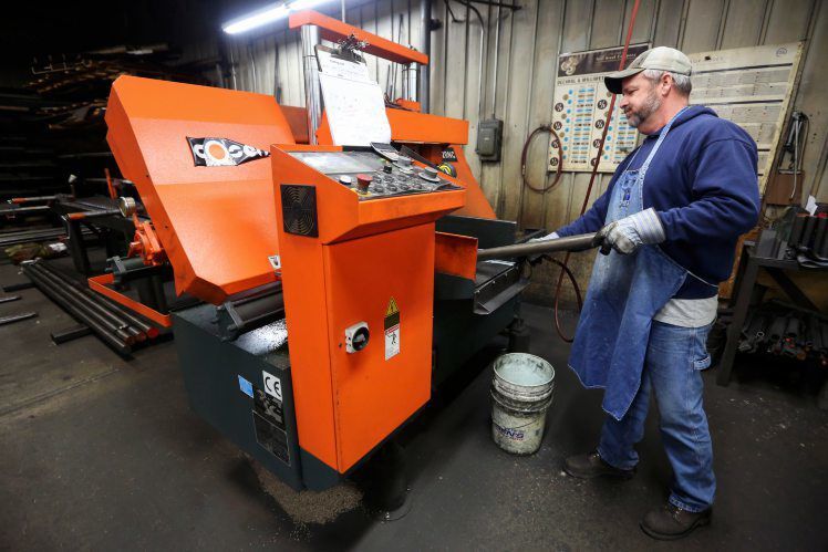 Rich Poll operates an automatic band saw at T&J Manufacturing in Maquoketa, Iowa.    PHOTO CREDIT: NICKI KOHL
