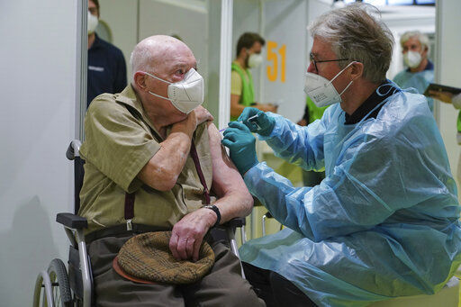 A doctor inoculates Herri Rehfeld, 92, against the new coronavirus with the Pfizer/BioNTech vaccine at the vaccination center at the Messe Berlin trade fair grounds on the center