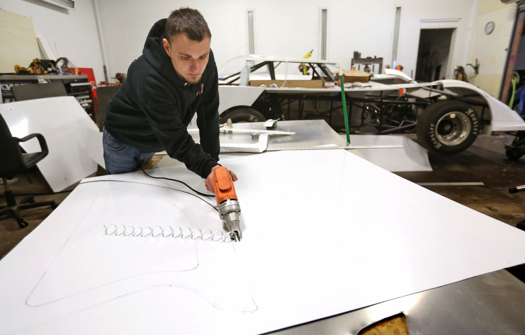 Tyler Madigan cuts a piece of sheet metal while working on a roof of a late model racing car at TMR Enterprises in Dubuque on Friday, Jan. 15, 2021. PHOTO CREDIT: JESSICA REILLY