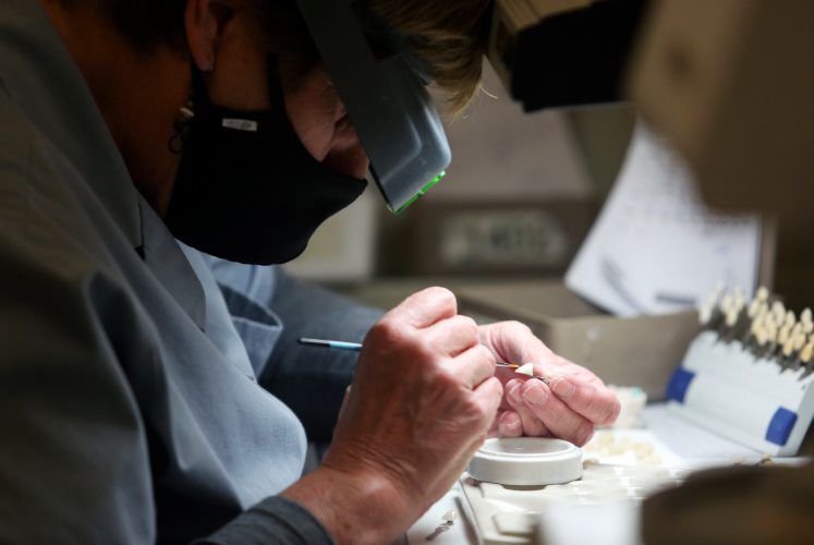Sherry Grutz works to stain a tooth. PHOTO CREDIT: NICKI KOHL