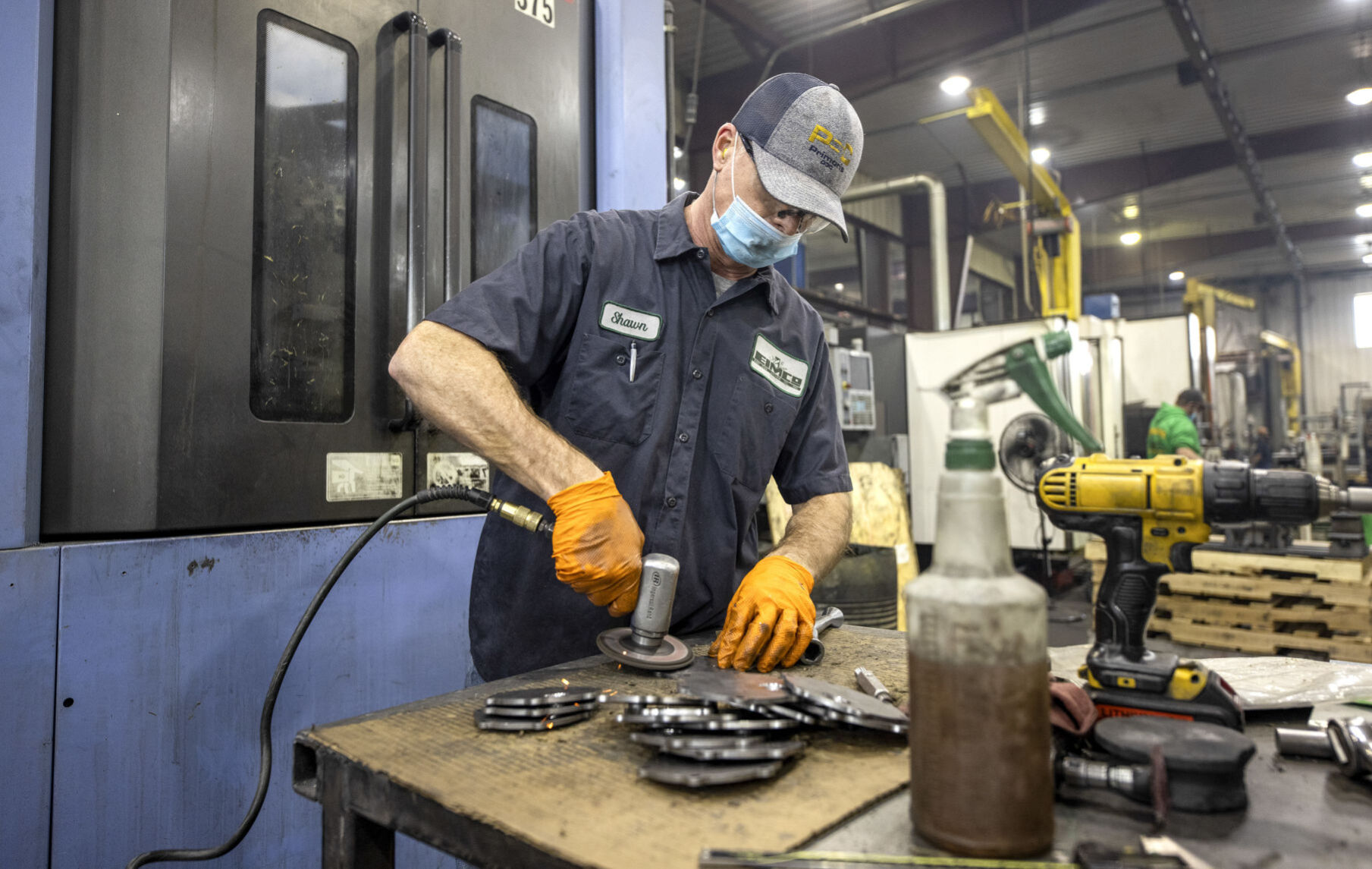 Shawn Burchard, an employee of EIMCO, grinds parts in the Farley, Iowa, plant. PHOTO CREDIT: Jacob Fiscus