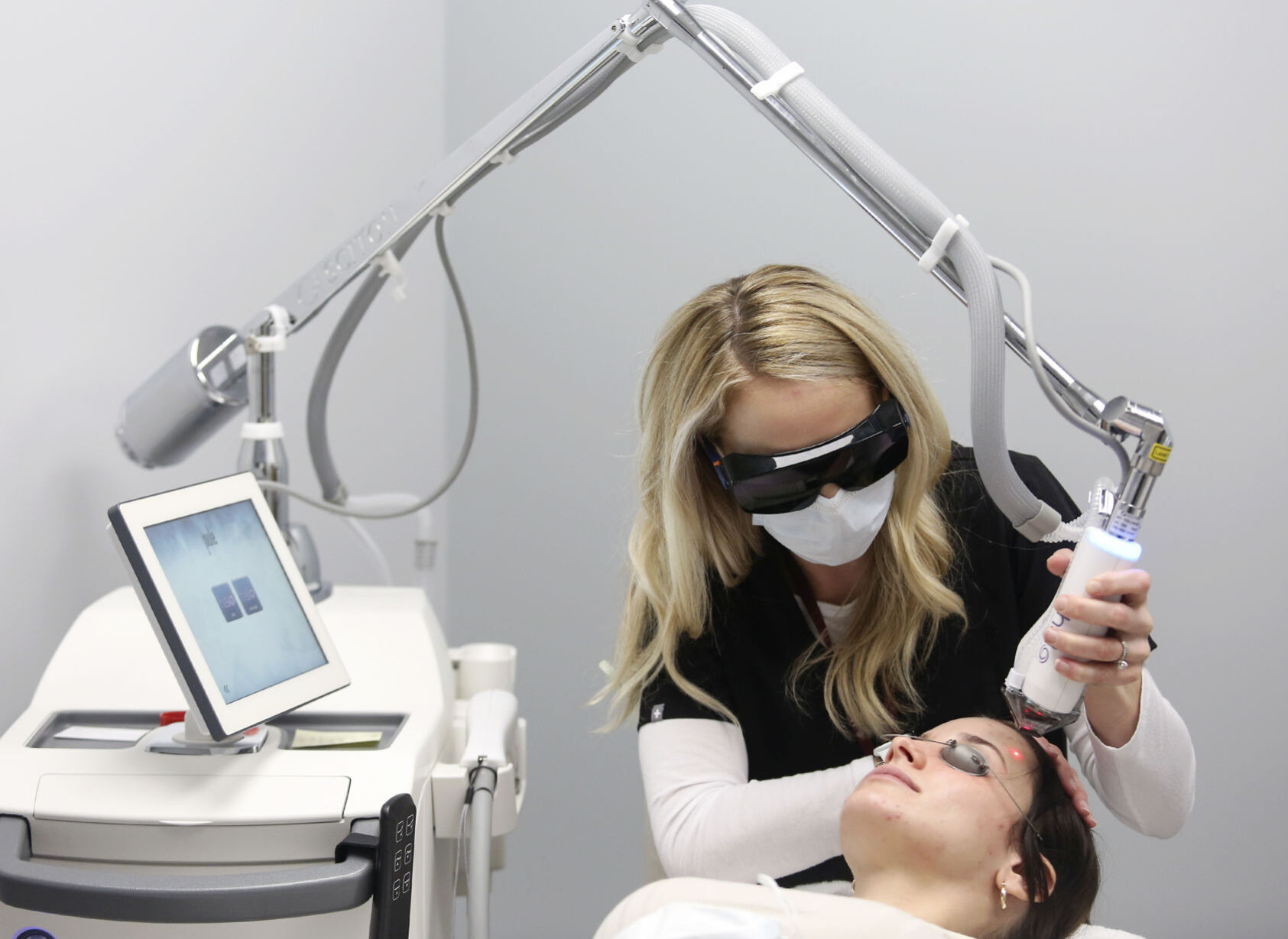 Emily May (top) demonstrates the use of a Halo laser for skin resurfacing on Jordan Christensen at The Aesthetic Center by Medical Associates in Dubuque on Friday, Jan. 29, 2021. PHOTO CREDIT: NICKI KOHL