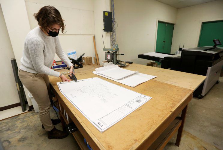 Natalie Gassman binds blueprints at Tri State Blueprint and Framing. PHOTO CREDIT: NICKI KOHL