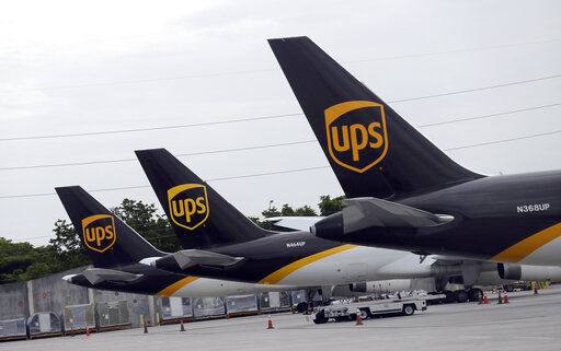 In this July 27, 2020 file photo, the tails of three UPS aircraft are shown parked at Miami International Airport in Miami. UPS, whose brown delivery trucks have become omnipresent on neighborhood streets during the pandemic, is reporting strong profits and revenue in its most recent quarter. (AP Photo/Wilfredo Lee, File) PHOTO CREDIT: Wilfredo Lee