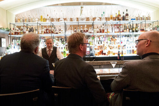 In this Tuesday, Nov. 27, 2018, photo, a bartender talks to a customer at the Gotham Bar and Grill in New York. The Manhattan upscale restaurant hopes to reopen by summer 2021 if government regulations permit, but will likely have just 35 staffers instead of the 100 the restaurant had before it closed in March 2020. (AP Photo/Mary Altaffer) PHOTO CREDIT: Mary Altaffer