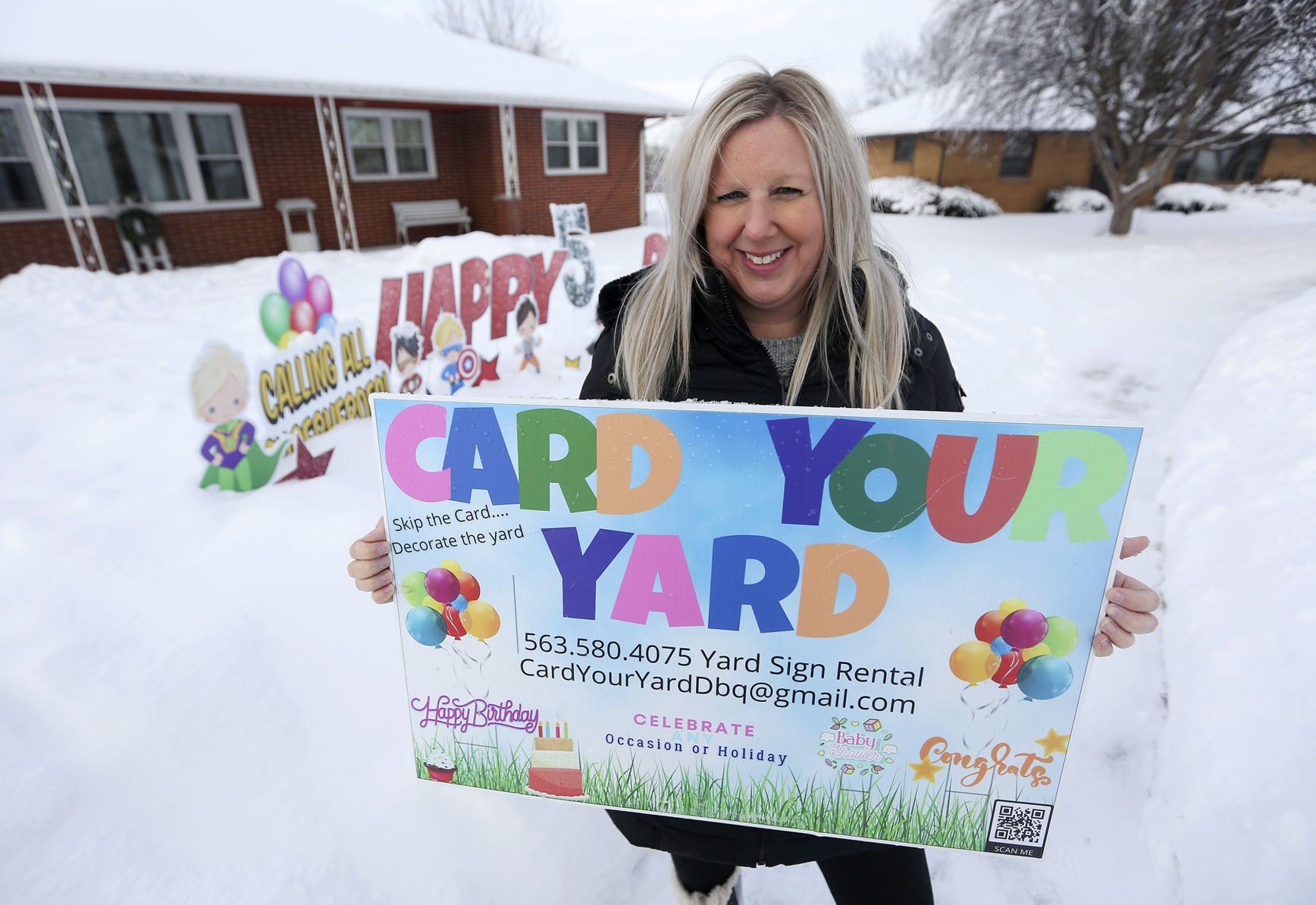 Jill Keck, owner of Card Your Yard Dubuque, stands in front of a current display in Dubuque on Friday. PHOTO CREDIT: NICKI KOHL