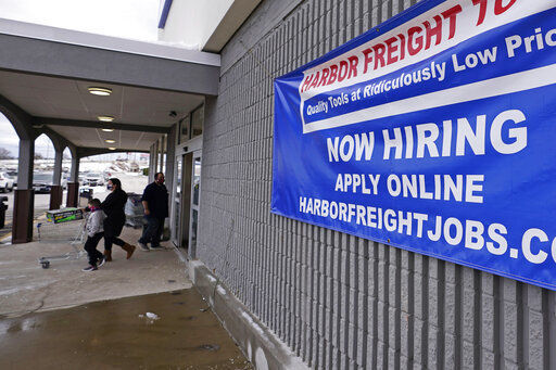 A “Now Hiring” sign hangs on the front wall of a Harbor Freight Tools store in Manchester, N.H., but U.S. employers cut back sharply on hiring in December, particularly in pandemic-hit industries such as restaurants and hotels. PHOTO CREDIT: Charles Krupa