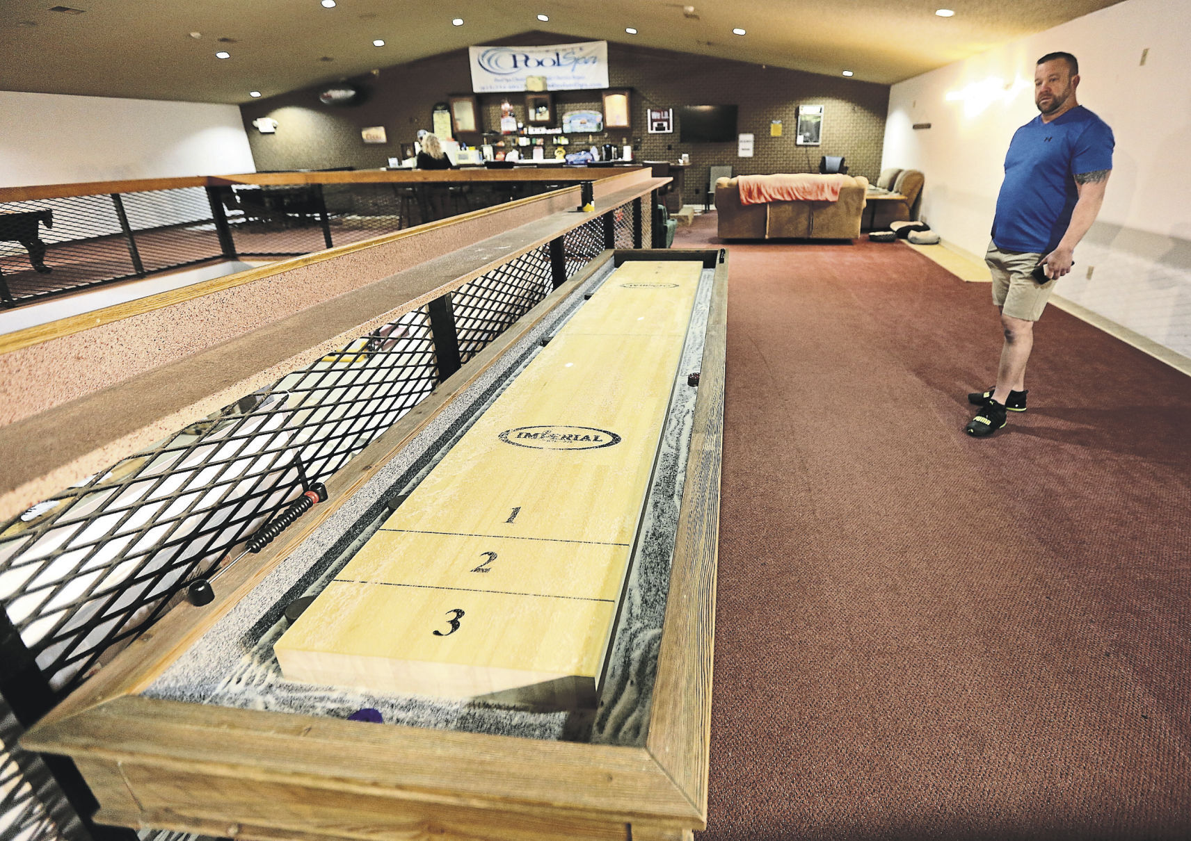 Owners of Tri-State Pool & Spa in East Dubuque, Ill., Luke Tigges looks over a shuffle board on display in their store. PHOTO CREDIT: Dave Kettering
