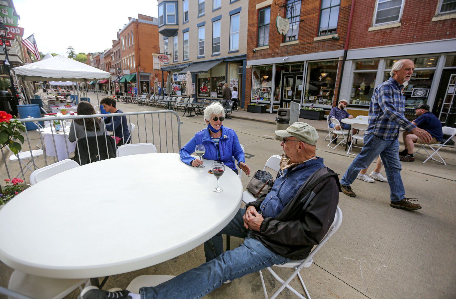 Ruth Feece and her husband, Darrell, of Galena, Ill., enjoy a glass of wine at Paradise Bar and Grill on Galena’s Main Street in May. The city closed parts of Main Street last year to allow businesses to provide outdoor seating for their customers, and a similar plan is in place for 2021. PHOTO CREDIT: Dave Kettering, Telegraph Herald